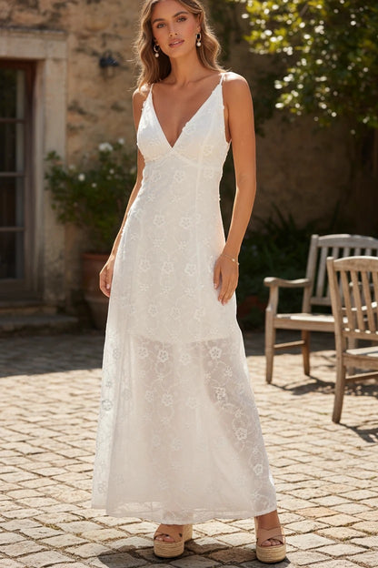 Robe de demoiselle d'honneur Valerelle longue et blanche en dentelle florale avec col en V, portée en extérieur.