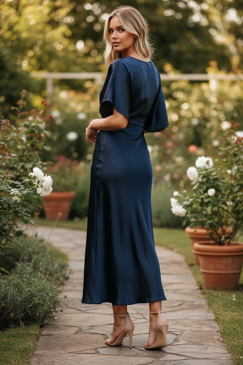 Robe de demoiselle d'honneur longue Valerelle bleu nuit fluide avec manches courtes dans un jardin fleuri