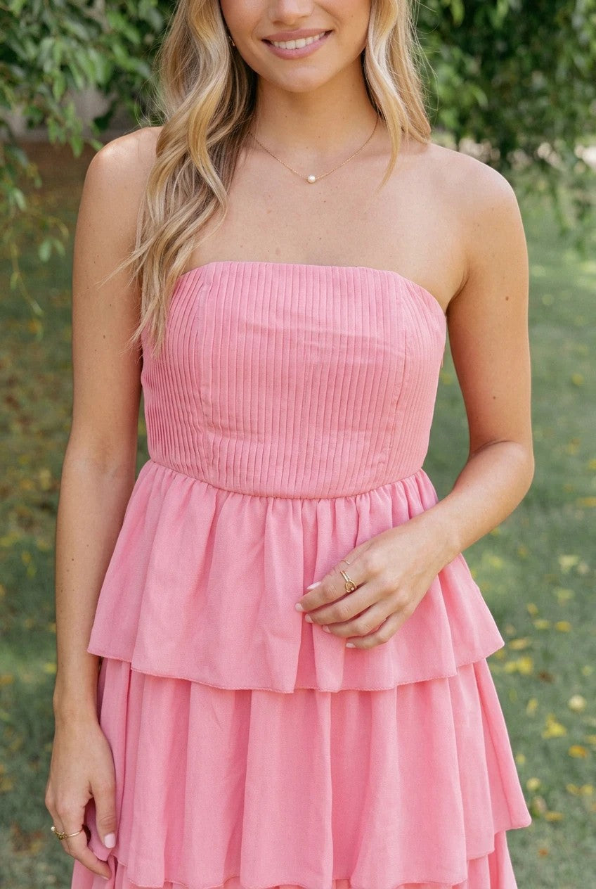Robe longue Valerelle bustier corail à volants portée par une femme en extérieur