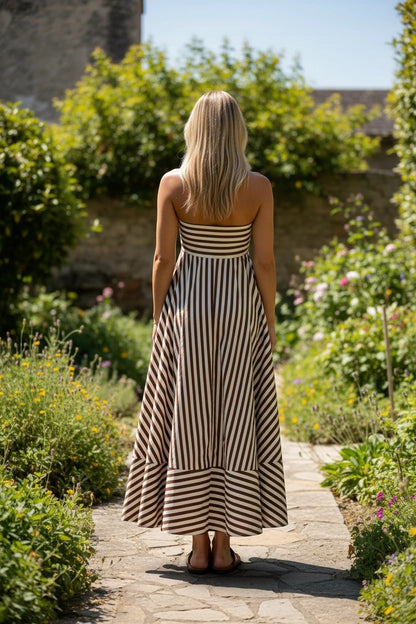 Robe longue bustier Valerelle à rayures chocolat et blanc, portée par une femme dans un jardin ensoleillé.