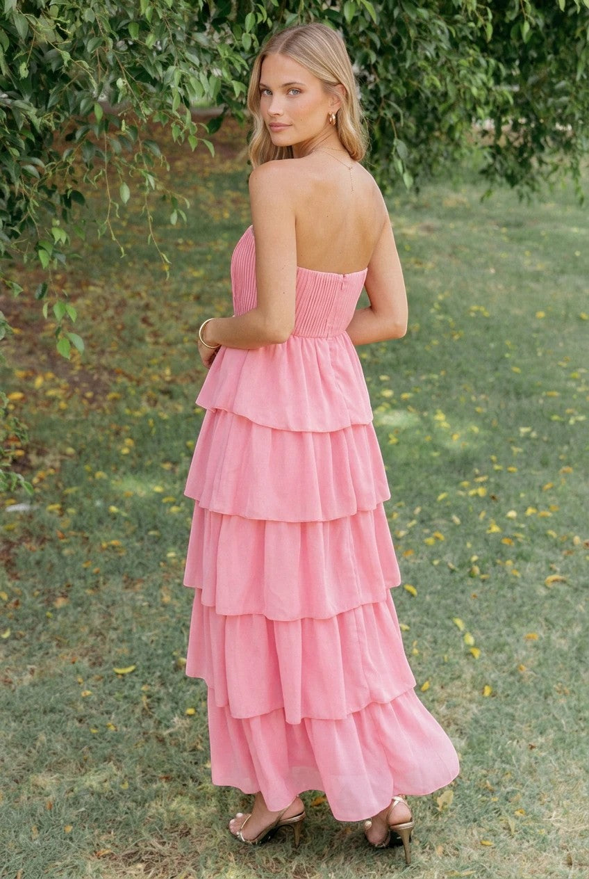 Robe longue Valerelle corail à étages avec bustier, portée par une femme dans un jardin.