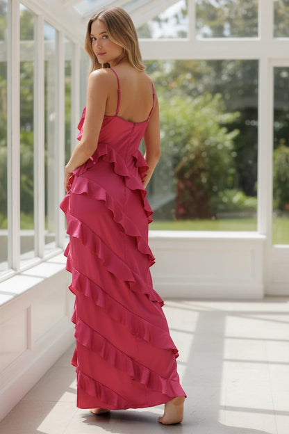 Robe longue Valerelle fuchsia en satin avec volants, portée par une femme dans une véranda lumineuse