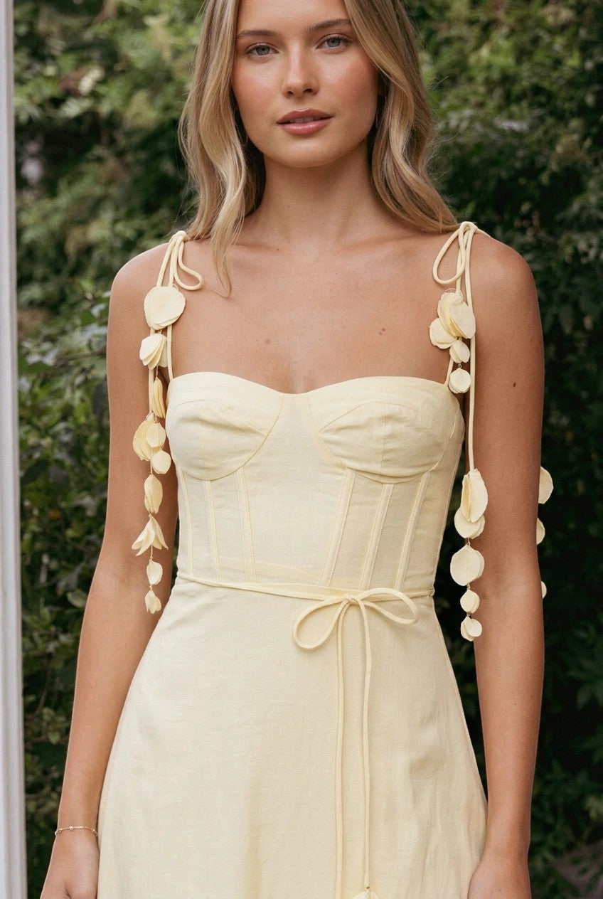 Robe midi Valerelle jaune pastel avec corset, bretelles à détails floraux et coupe cintrée portée par une femme