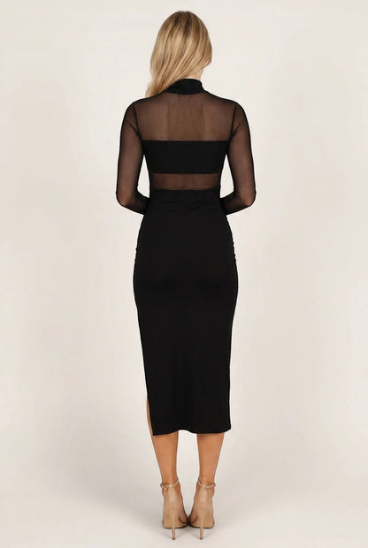 Robe midi noire Valerelle cintrée avec empiècement en tulle transparent au dos, portée par une femme blonde