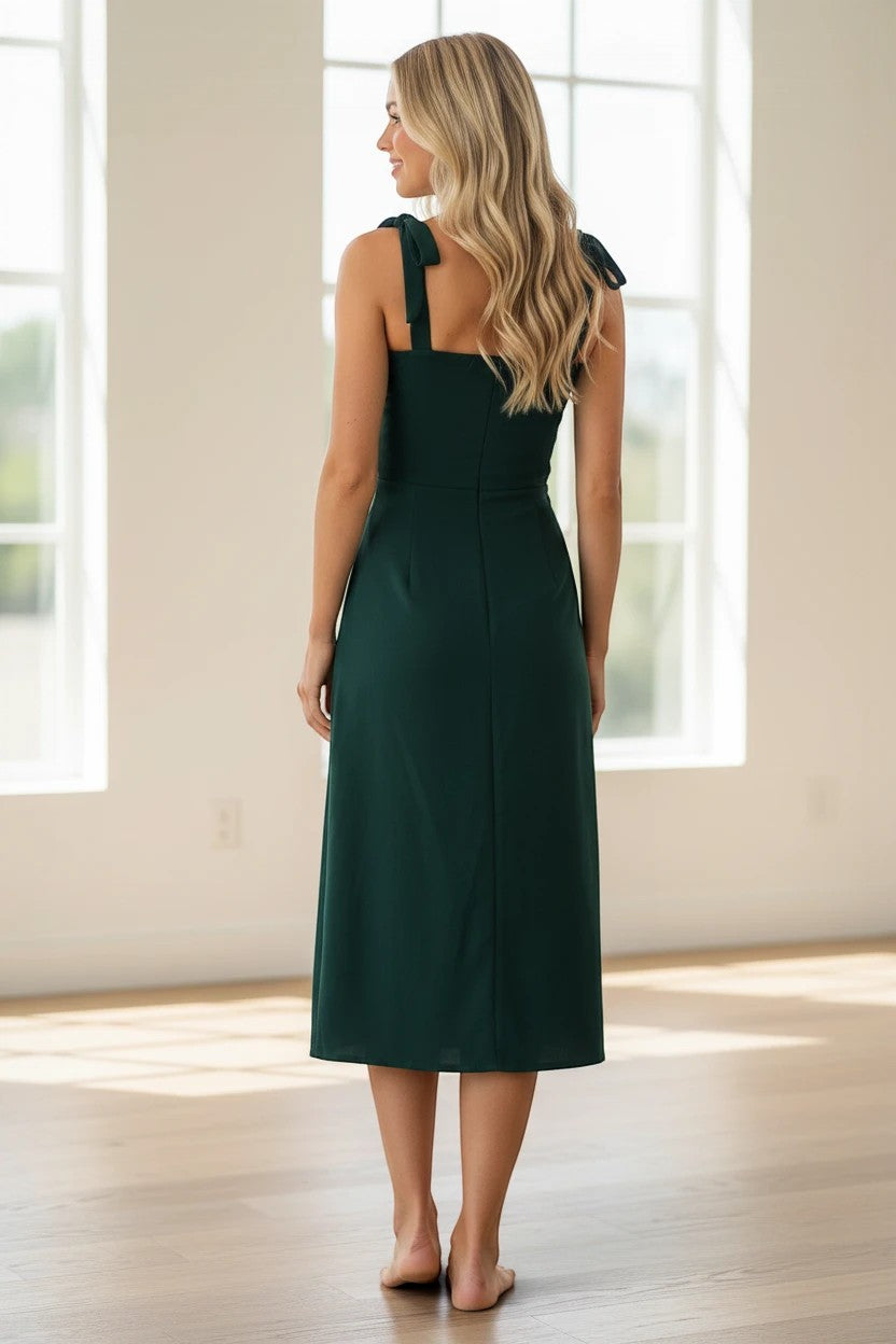 Robe midi Valerelle vert émeraude cintrée avec bretelles à nouer, vue de dos sur une femme aux cheveux blonds