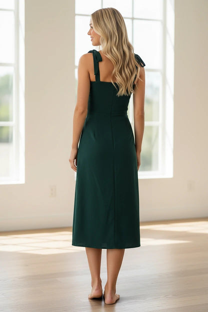 Robe midi Valerelle vert émeraude cintrée avec bretelles à nouer, vue de dos sur une femme aux cheveux blonds