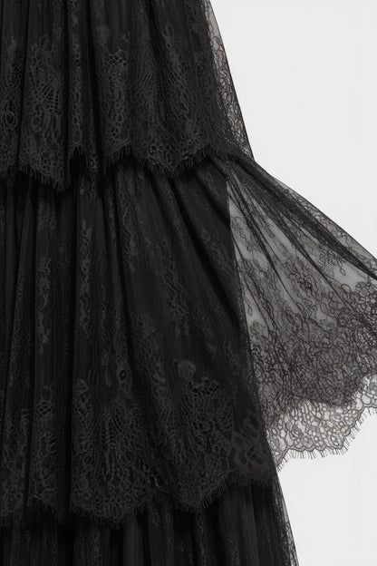 Gros plan sur la dentelle noire raffinée d'une robe de soirée longue Valerelle avec des détails de volants délicats.