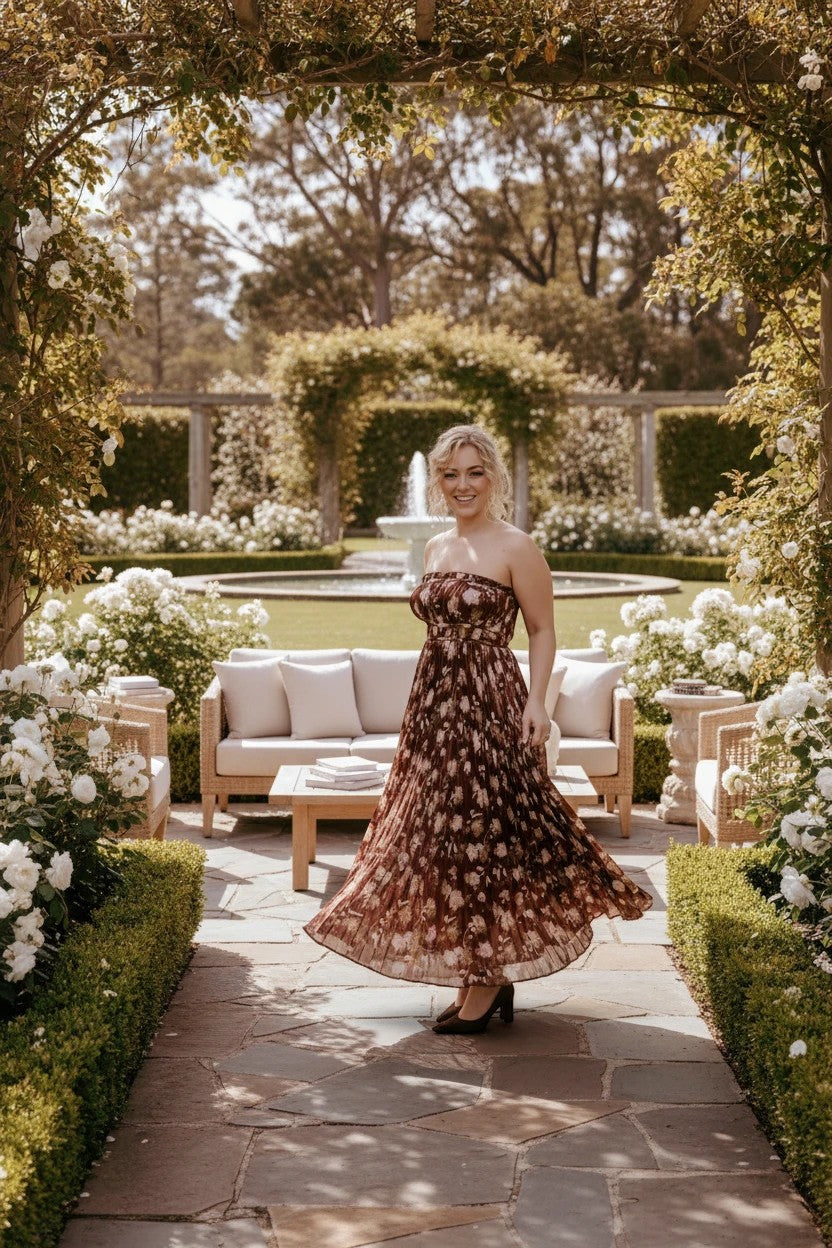 Femme portant une robe de soirée longue Valerelle bustier marron à imprimé floral dans un jardin élégant