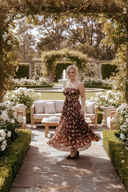 Femme portant une robe de soirée longue Valerelle bustier marron à imprimé floral dans un jardin élégant